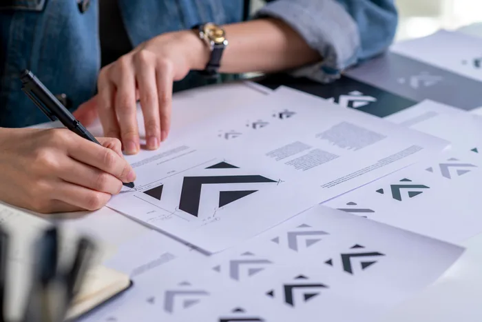 Designer desenhando propostas de logotipo em papel